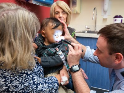 Provider shines a light to get a better look at a patient's mouth.